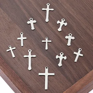 Set de 11 colgantes de cruz de acero inoxidable para joyería DIY sobre madera