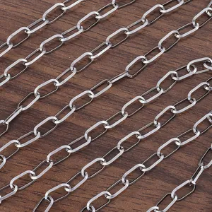 Polished stainless steel oval paperclip chain links for DIY jewelry making on wood background