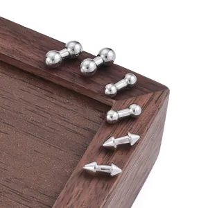 Polished stainless steel punk cone and ball stud jewelry set on a dark wood background