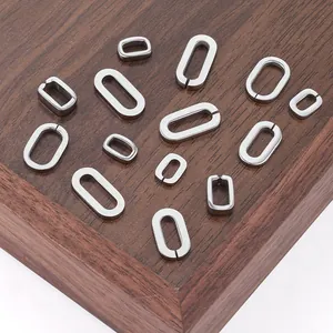 Polished stainless steel oval link connectors for DIY jewelry making on wooden tray