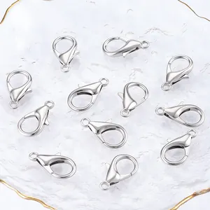 Detail showing 12 silver-tone alloy lobster clasps on a glass tray for DIY jewelry making