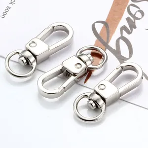 Gros plan de trois mousquetons rotatifs en argent poli pour accessoires de sacs