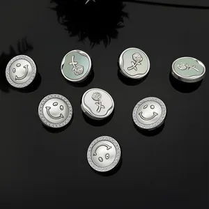 Detailed view of luxury metal flower buttons and silver smile face badges with rhinestones