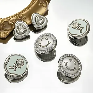 Detailed macro view of rhinestone heart and smile face metal buttons in a golden vintage frame