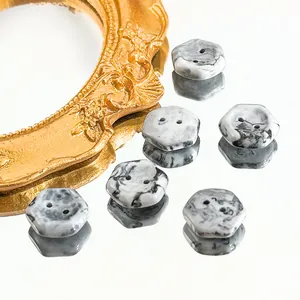 Detail of six hexagonal marble pattern buttons with dual holes for DIY sewing on white surface
