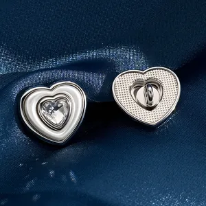 Silver heart-shaped buttons with rhinestones on a blue fabric, front and back view