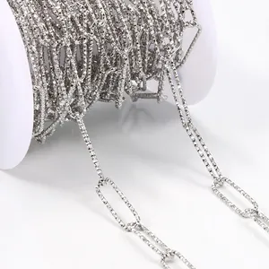 Macro shot of silver stainless steel paperclip chain with textured links on white spool