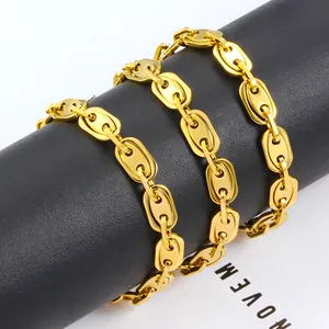 Polished gold stainless steel coffee bean link necklace on a black leather display stand