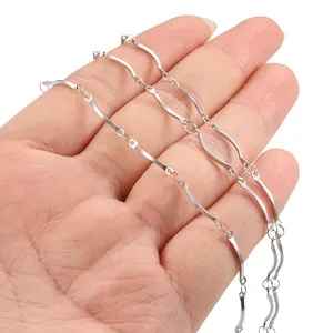 Polished silver wave chain necklace in stainless steel shown being held in hand