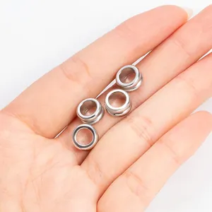 Gepolijste roestvrijstalen tussenkralen voor DIY-sieraden, getoond op een vinger