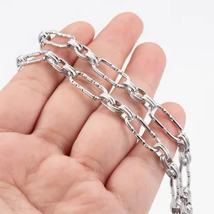Silver stainless steel oval link chain with textured surface held in hand for DIY jewelry