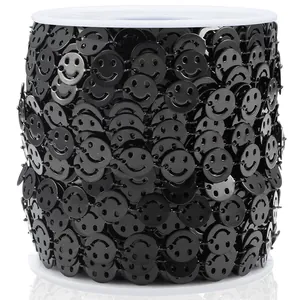 Gros plan de garniture de chaîne à paillettes smiley noir enroulée sur bobine