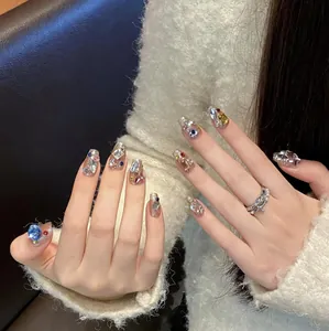 Macro detail of long coffin press-on nails with colorful rhinestones and gem accents