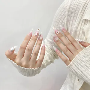 Detail of long almond press-on nails with 3D white flowers and pink gradient glitter