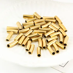 Golden stainless steel curved tube spacer beads for DIY jewelry making in a white tray