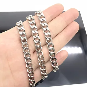 Polished stainless steel Cuban link chain necklace held by hand over a black reflective surface
