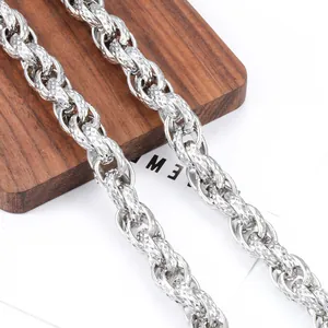 Silver stainless steel thick chain necklace with diamond-cut texture on wooden background