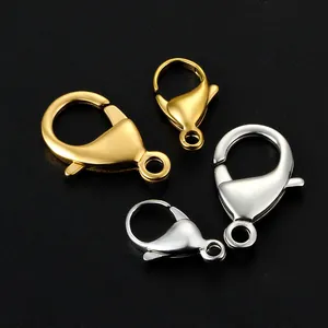 Polierte Edelstahl Karabinerverschlüsse in Gold und Silber auf schwarzem Hintergrund