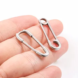 Orecchini a forma di spilla da balia in acciaio inossidabile argento mostrati sulla mano
