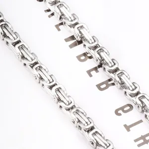 Polished silver Byzantine style stainless steel chain necklace in a 45-degree macro view