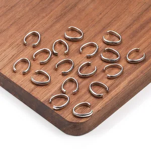 Polished silver stainless steel oval connector rings for DIY jewelry on wood surface