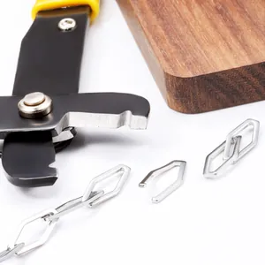 Handmade rhombus chain link with yellow jewelry pliers on a wooden background