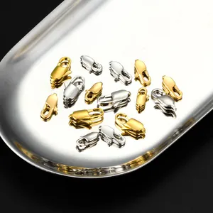 Macro detail of gold and silver lobster clasps for DIY jewelry on a metal tray
