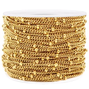 Macro shot of 18K gold plated satellite chain on white spool for jewelry making DIY
