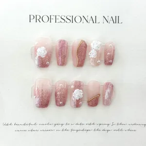 Detail of handmade press-on nails with 3D white roses, pearls and pink gradient finish