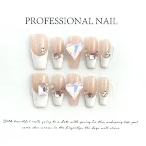 Detail of handmade press-on nails with French white tips, pearls and heart crystals