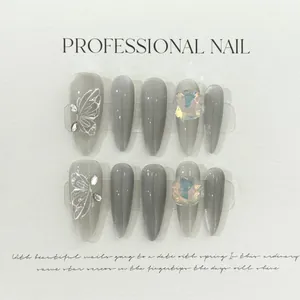 Detailed macro view of 3D butterfly art and luxury rhinestones on grey cat-eye press-on nails