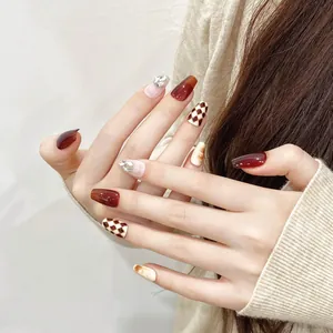 Unghie finte fatte a mano bordeaux con motivi a scacchi e accenti di strass eleganti