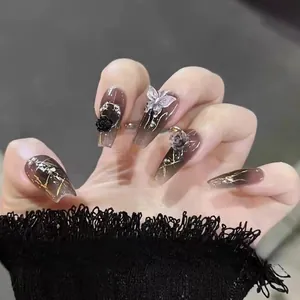 Macro detail of handmade press-on nails with 3D silver butterfly and black relief roses