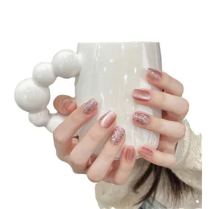 Sparkly press-on nails with pink cat eye effect and glittery rhinestones design