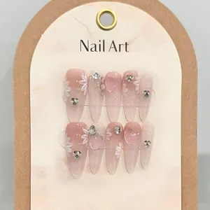 Detail of pink gradient press-on nails with 3D floral art and luxury rhinestone accents