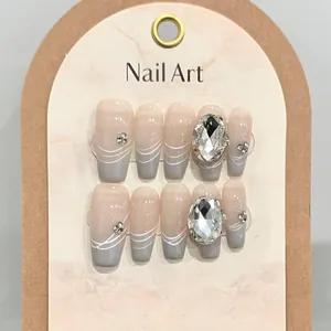 Detailed view of long coffin press-on nails with blue gradient, rhinestones and jewels