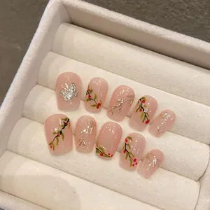 Detailansicht handbemalter Kunstnägel mit roten Beeren und Schmetterlingsmotiven in Box