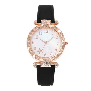 Elegant rose gold women's watch with starfish dial and black leather strap on white background