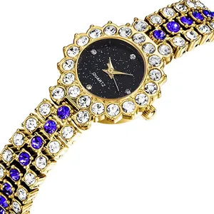 Dettaglio dell'orologio dorato con quadrante stellato nero e cinturino con diamanti viola
