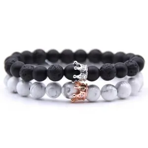 Detail of volcanic stone and white turquoise bead bracelets with crown charms
