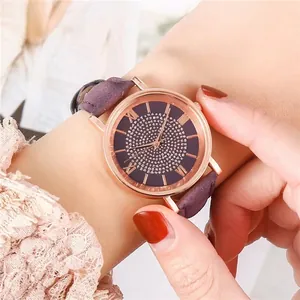 Detail of rose gold watch with purple diamond dial and leather strap worn by a model