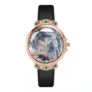 Détail de montre rose doré avec cadran marbre, motif cerf et gemmes colorées