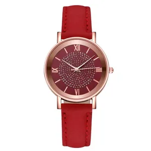 Detailed close-up of rose gold watch case with red leather strap and rhinestone dial