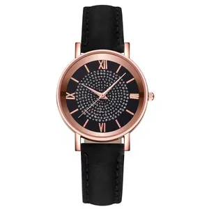 Detail of rose gold quartz watch with rhinestone-studded dial and black leather strap
