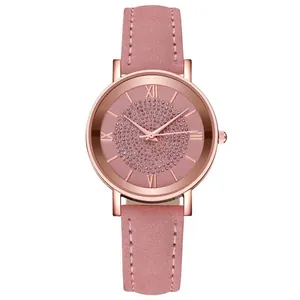 Macro detail of starry rose gold watch face with roman numerals and pink leather strap
