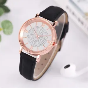 Close-up of rose gold watch with sparkling crystal dial and black leather strap
