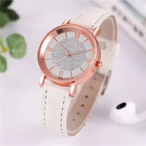 Detail of rose gold quartz watch with rhinestone dial and white leather strap