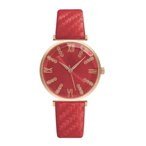 Detail of red dial with Roman numerals and rose gold case on woven texture strap