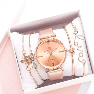Détail d'une montre à quartz rose doré et bracelets dorés avec breloque Love en coffret