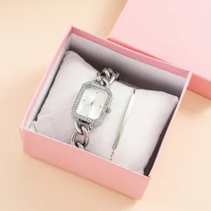 Detail view of square dial watch and silver bangle presented in an elegant gift box